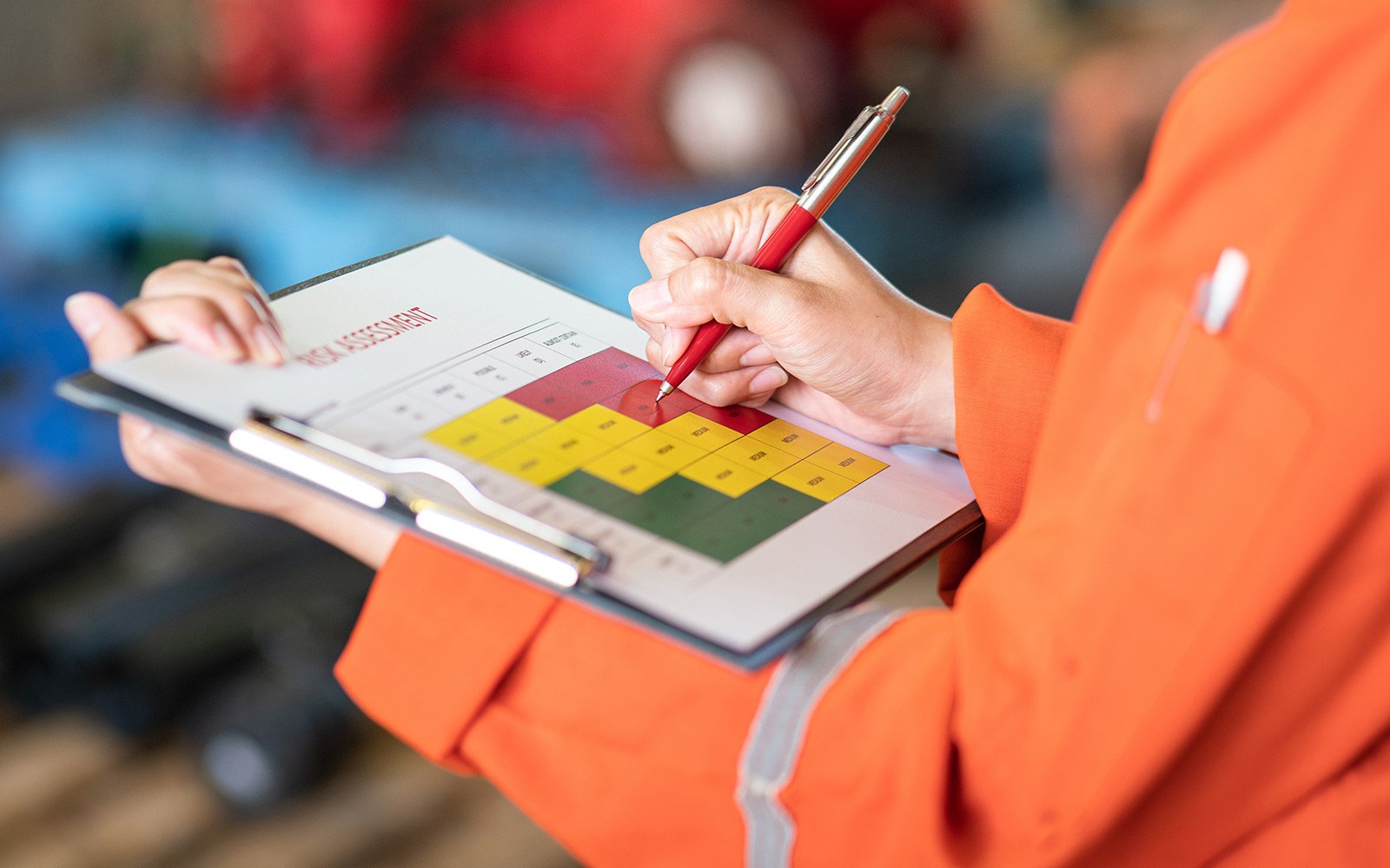 Person schreibt in Formular auf Klemmbrett – Symbolbild für Dokumentation der Arbeitsschutzunterweisung im Betrieb